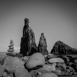 Stack of stones on beach against clear sky