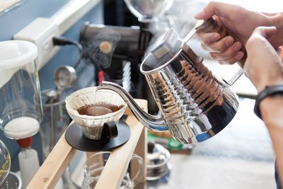 Midsection of man preparing coffee in cafe