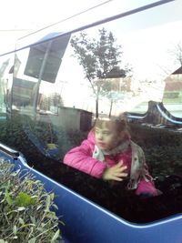 Rear view of woman looking through car window