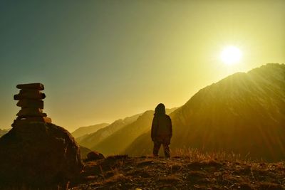 Rear view of man walking on mountain against sky