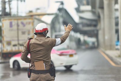 Rear view of police man standing on street