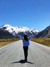 Rear view of man walking on snow covered mountain