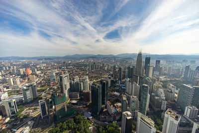 High angle view of cityscape against cloudy sky