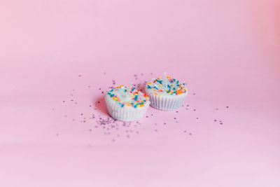 High angle view of cupcakes against colored background