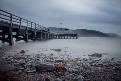 Pier at sea shore against sky