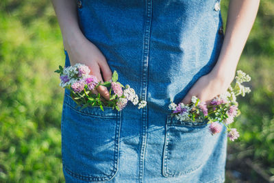 Midsection of woman holding flowering plant