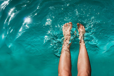 Low section of person legs in swimming pool