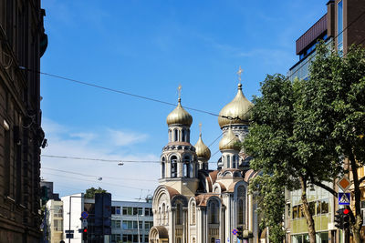 Buildings and church against blue sky