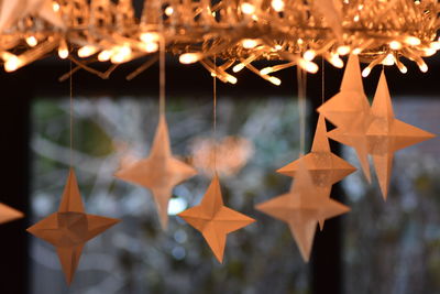 Close-up of illuminated christmas decorations hanging on paper