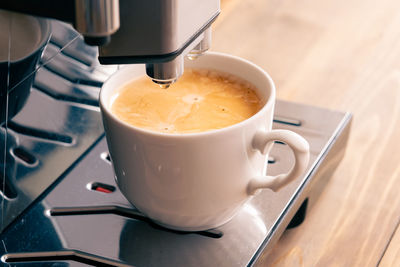 Espresso coffee preparation on a wooden table in white cup