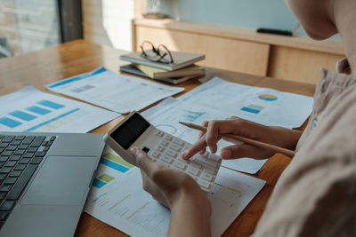 Midsection of businessman preparing financial bill