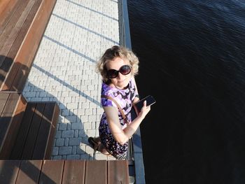 Low angle view of young woman standing against sea