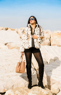 Portrait of fashion young woman standing at beach