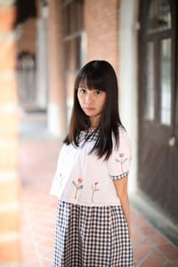 Portrait of beautiful woman standing at corridor