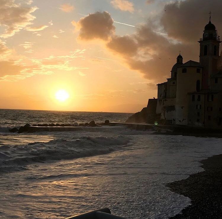 SEA AND BUILDINGS AGAINST SKY DURING SUNSET