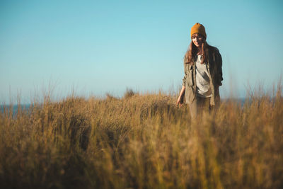 Woman standing on field against sky