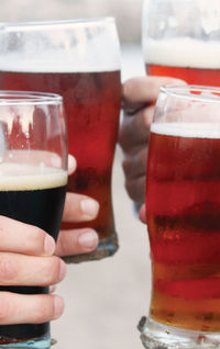 Cropped hands of people toasting beer glasses