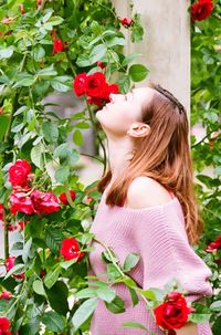 Woman smelling red flowering plants