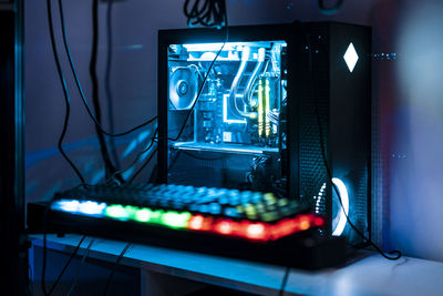 Illuminated computer keyboard and cpu on table in studio