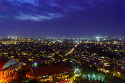 Illuminated cityscape against sky at night