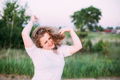 Cheerful woman standing in forest