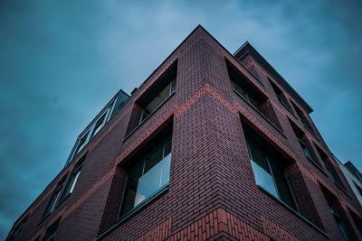 Low angle view of modern red house against sky - long exposure