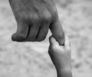 Close-up of woman hand holding sand at beach