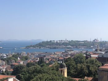 High angle view of townscape by sea against sky