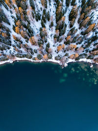 Braies, bolzano - aerial view of lake braies with drone in autumn during the first snowfall.