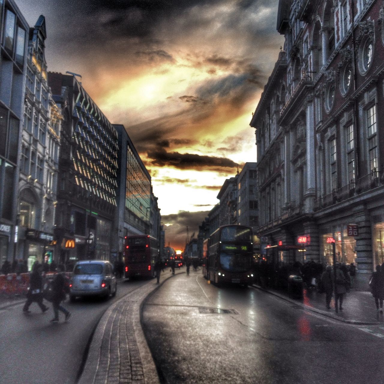 building exterior, architecture, built structure, street, city, transportation, car, land vehicle, sky, the way forward, city life, sunset, city street, road, illuminated, mode of transport, diminishing perspective, cloud - sky, incidental people, dusk