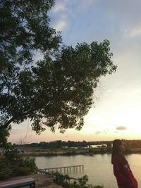 Woman by lake against sky