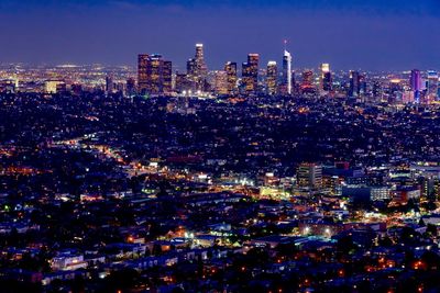 Illuminated cityscape against sky at night