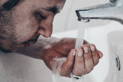 Close-up of man washing hands