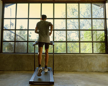 A man walking and exercising on a treadmill.