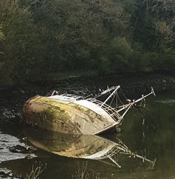 Abandoned boat moored at lake