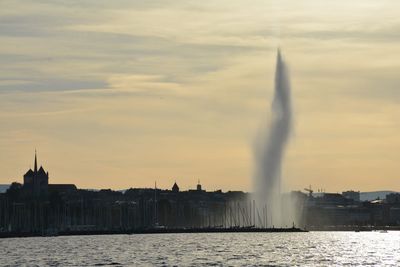 View of fountain against cloudy sky during sunset