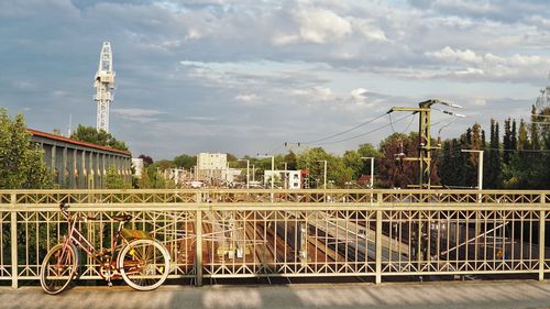 Bridge over river by buildings against sky