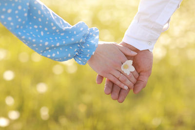 Cropped image of couple holding hands