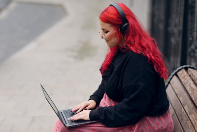 Side view of young woman using mobile phone