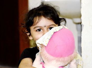 Portrait of cute girl holding toy at home