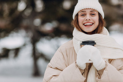 Portrait of smiling young woman standing outdoors