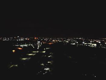 Illuminated cityscape against sky at night