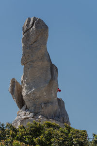 Low angle view of rock formation against clear blue sky