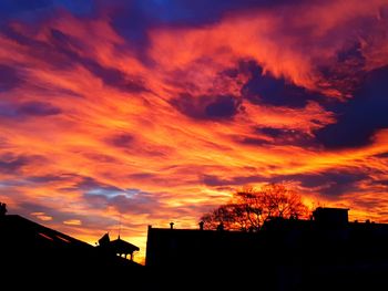 Silhouette city against sky at sunset