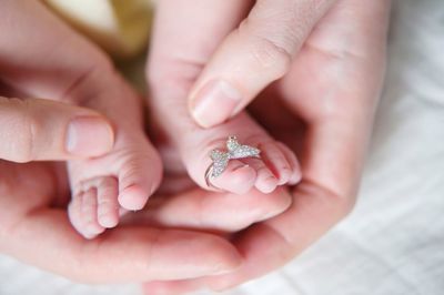 Cropped hands of woman touching feet of baby