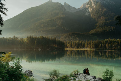 Scenic view of lake by mountains against sky