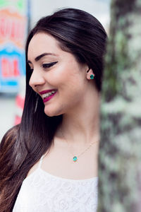 Close-up of young woman looking away while standing outdoors