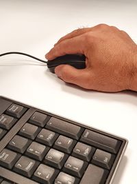 Close-up of man hand using computer mouse on table