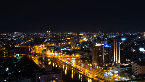 High angle view of illuminated buildings against sky at night