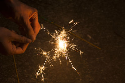 Close-up of hand holding sparkler at night